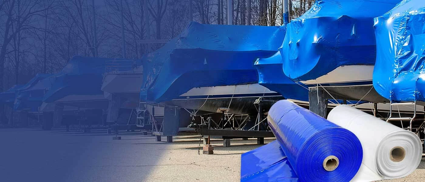 Marina yard with a line of boats wrapped in blue marine shrink wrap