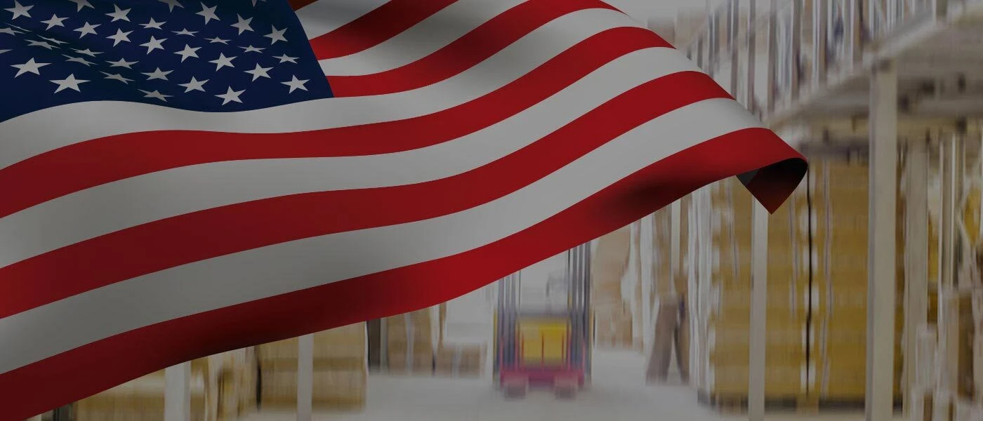 American flag waving in front of a warehouse background