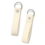A cream-coloured key ring with a smooth leather-like strap and a metal ring attached. It features a silver button.