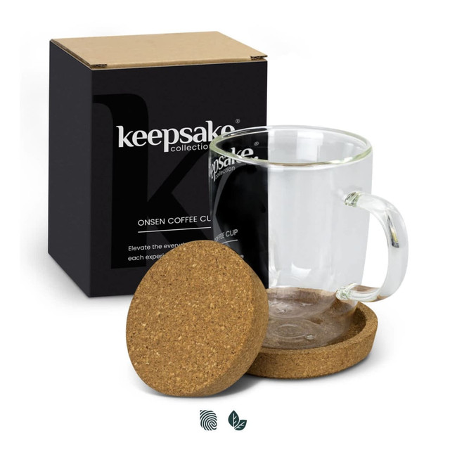 A transparent glass coffee mug with a cork coaster, presented in a black box.