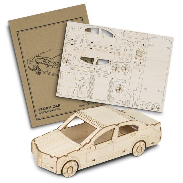 A wooden model of a sedan car with laser-cut pieces displayed alongside its packaging. The model features a natural wood finish.