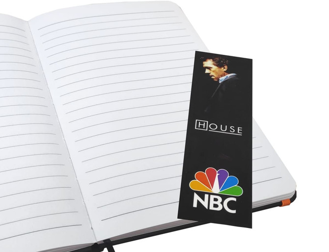 A notepad with lined pages and an orange elastic band, featuring a bookmark with a logo and image.