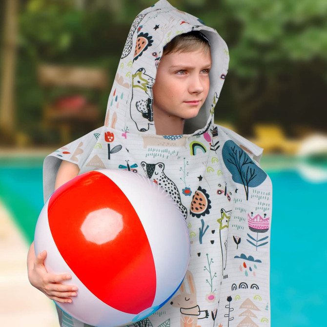 A hooded towel in light grey with colourful prints, featuring a child holding a red and white beach ball.
