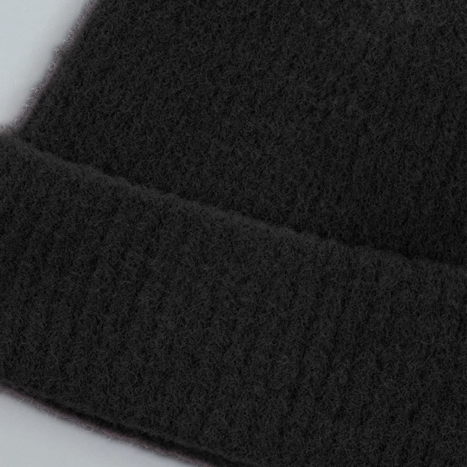A black beanie with a ribbed cuff, made from soft, textured material, featuring a logo on the side.
