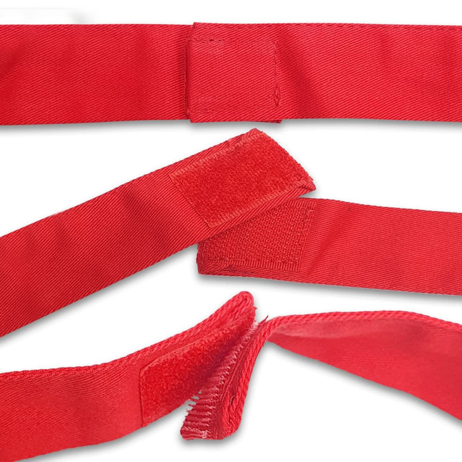 A bright red apron with velcro fastenings is displayed, showcasing its fabric texture and design.