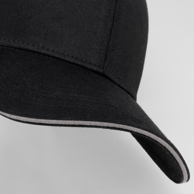 A black six-panel cap with a curved brim and contrasting trim, featuring a logo on the front.