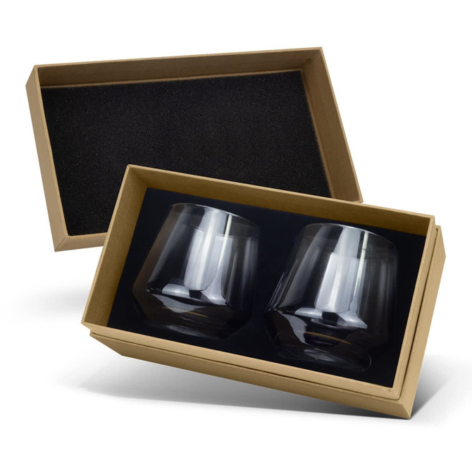 A gift box containing two clear, dark-coloured whiskey glasses with a sleek, modern design.