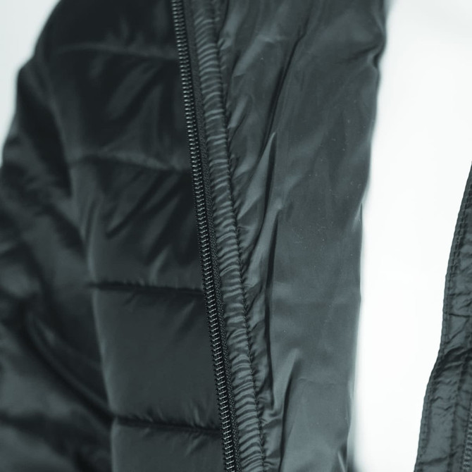 A black women's puffer jacket featuring a zip and quilted design, with a logo on the fabric.