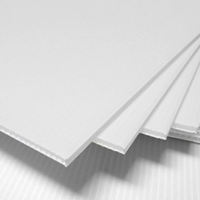 A stack of white core flute sheets with a ribbed texture, displaying multiple layers.