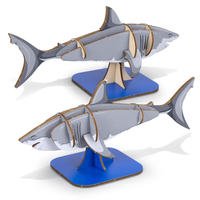 A model of a grey shark made from wood, displayed on a blue base, showcasing puzzle-like pieces.
