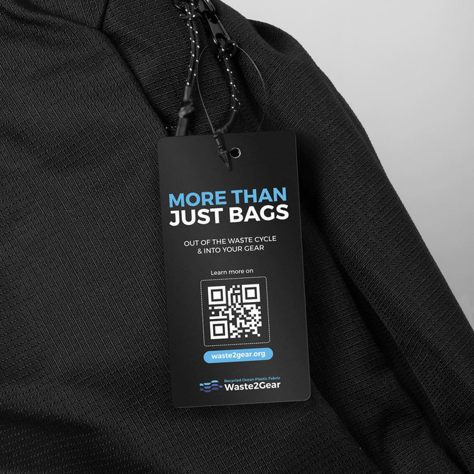 A black business computer backpack with a prominent tag highlighting its eco-friendly features.