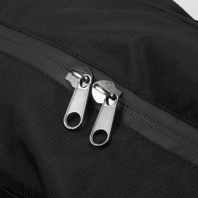 A black duffle bag featuring dual metallic zippers and a textured fabric surface. It has a logo on the material.