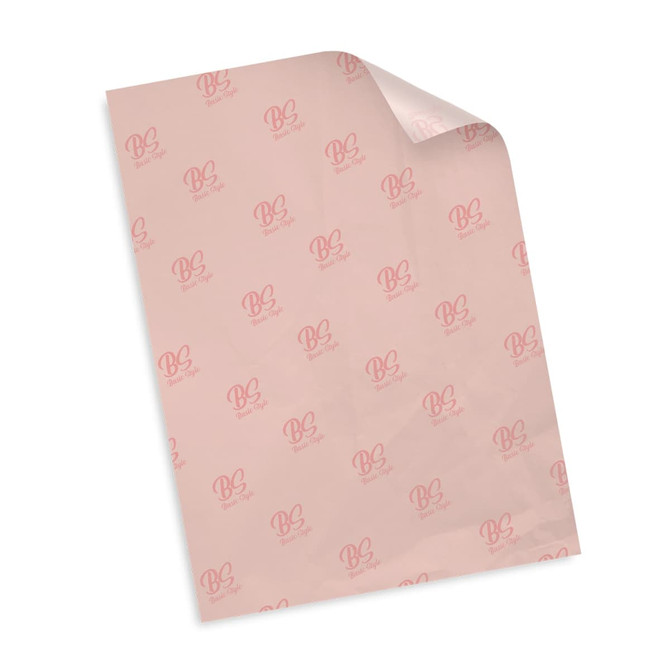 A sheet of pink tissue paper featuring repeated logos in a subtle pattern. The paper has a glossy finish.