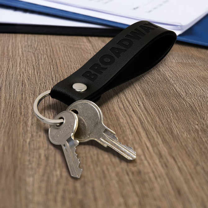 A key ring with a black leather strap and a metal keychain holding two silver keys.