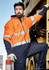 A unisex hi-vis softshell jacket in orange and navy, featuring reflective strips, worn by a person leaning against machinery.