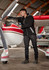 A man wearing a black unisex Sherpa fleece zip jumper, working on an aircraft engine in a hangar.