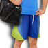 Custom men's sports shorts in blue and green, featuring a logo, paired with a black sports bag.