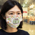 A reusable face mask in large size featuring colourful farm fresh produce designs. It has a logo on the front.