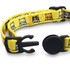 A yellow cat collar featuring various cat patterns and a black clasp, with a solid black adjustable attachment.