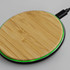 A bamboo wireless fast charger with a green LED ring, featuring a circular design and black base.