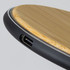 A bamboo wireless fast charger featuring a sleek black edge and a USB port.