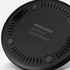 A wireless charger in black with circular design and ventilation holes, featuring a branding logo on the underside.