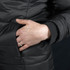 A close-up of a hand resting on a zip pocket of a black puffer jacket with ribbed cuffs.