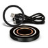 A black wireless charger with circular design and a USB charging cable in a coiled arrangement.