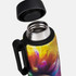 A drink bottle with a colourful design featuring shades of yellow, purple, and red, with a black lid and handle.