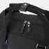 A black canvas duffle bag featuring sturdy handles and a zippered compartment. It has a branding logo.