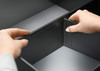 Cross divider fitted in drawer frame separating pan lids or jars