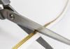 Scissors trimming a Sensio Razor X 4mm Pro free-cut LED flexible strip, demonstrating cut-anywhere technology for custom lighting installations.