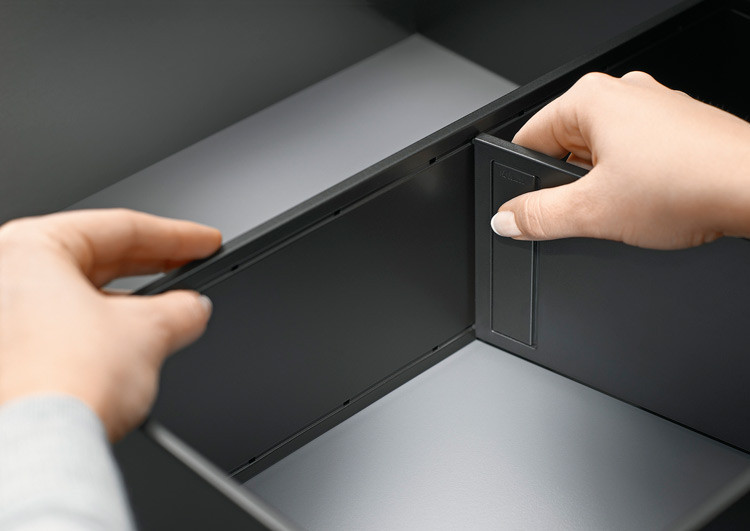 Cross divider fitted in drawer frame separating pan lids or jars