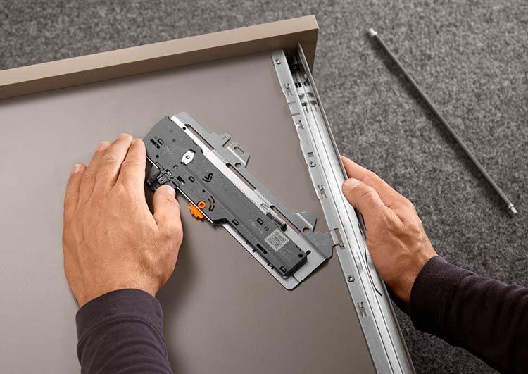 Mounting the TIP-ON BLUMOTION latch set into the lugs on the MERIVOBOX drawer side during installation