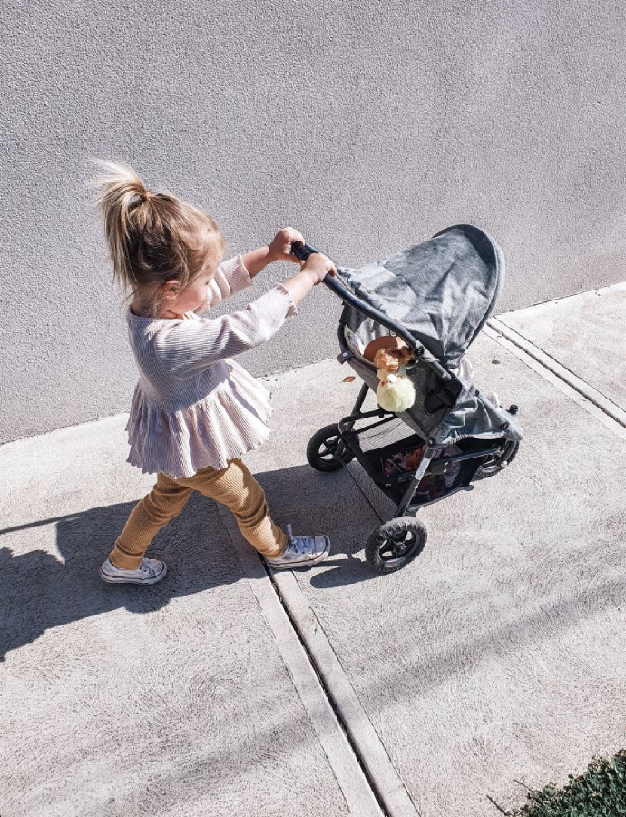 girl pushing grey marle runabout doll stroller