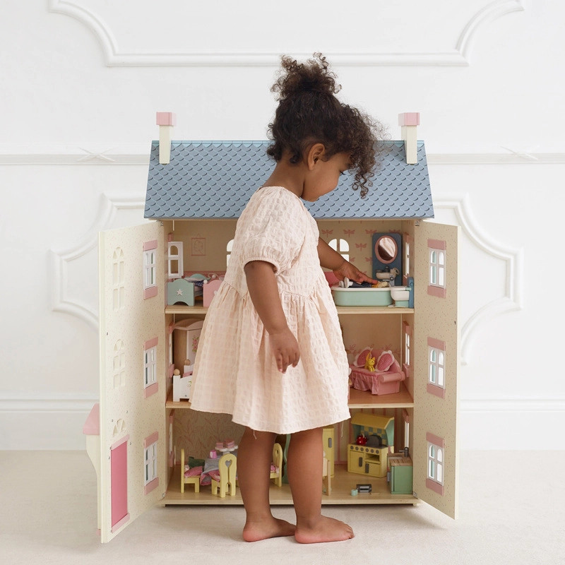 girl playing with le toy van cherry tree dolls house