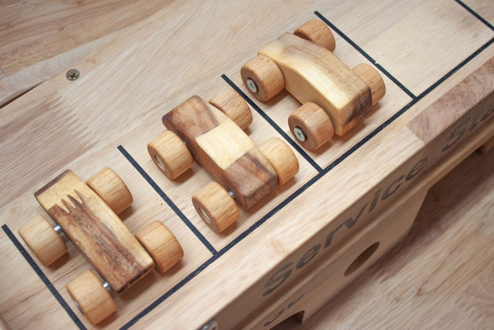 little wooden cars arranged on top of car garage