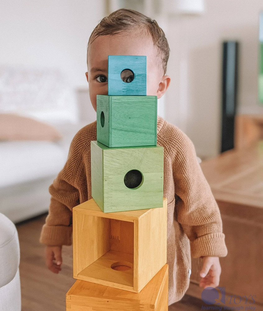 baby with rainbow nesting blocks