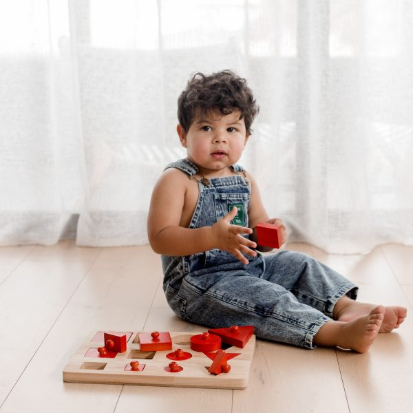 baby boy playing with knob puzzle