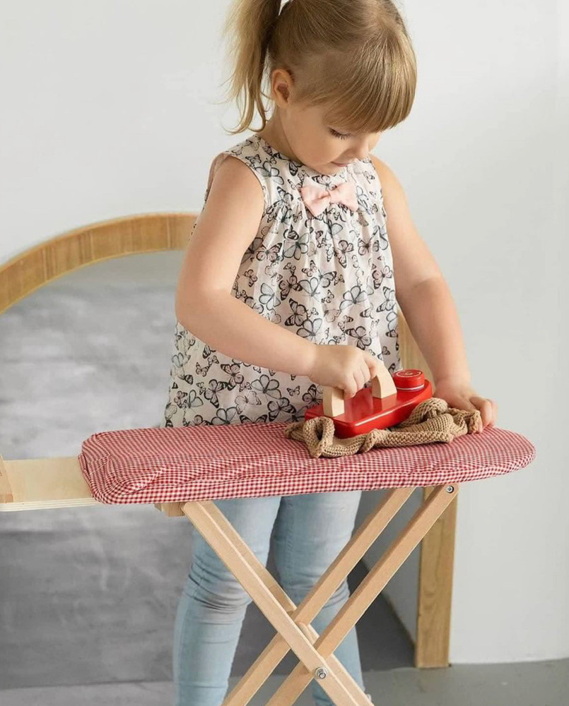 girl ironing with toy ironing board