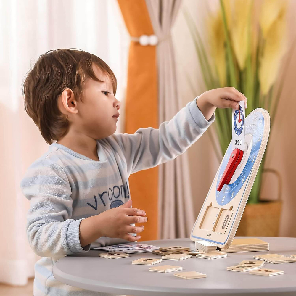 boy learning to tell the time with learning clock toy by viga