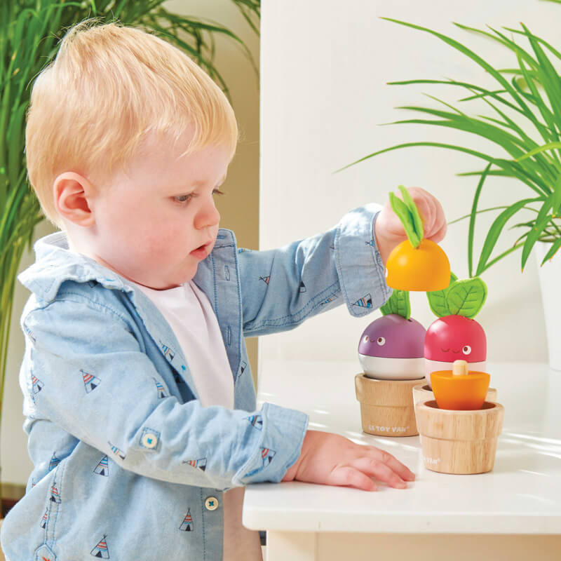 Young toddler playing with Le Toy Van Petilou Stacking Veggies