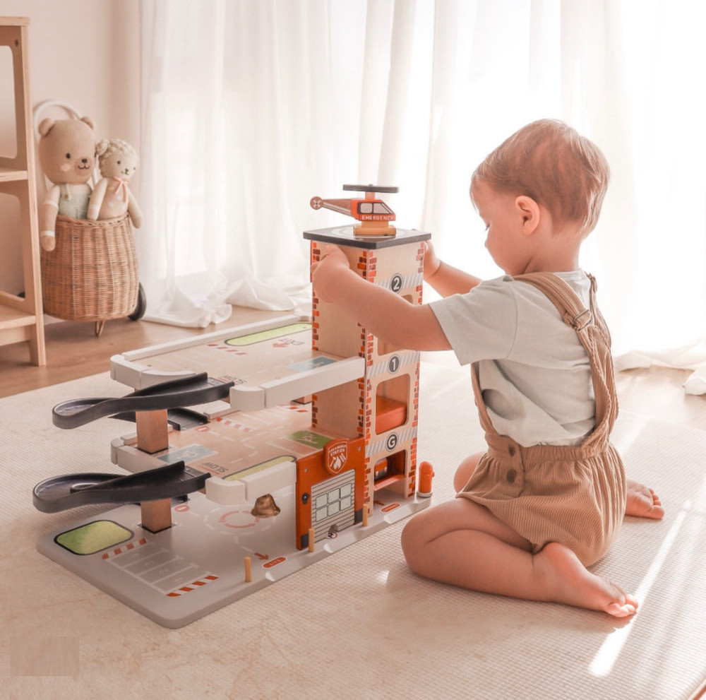boy playing with le toy van emergency vehicle garage playset