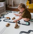 boy playing with qtoys wooden car set