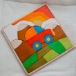 Tucks away neatly as a puzzle in a large wooden square tray with lowered edges to make pieces easy to pick up.