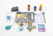 Includes various clinical tools such as stethoscope, heart monitor, medicine, syringe, thermometer, bandages, tongue depressor, tweezers, ointments, and a tray for organizing
