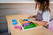 girl playing with kiddie connect dinosaur puzzle