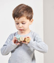 Child playing with Tender Leaf Timber Taxi wooden figures
