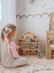 girl playing with classic wooden dollhouse