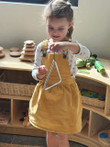 girl playing with musical triangle